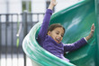 Hispanic girl sliding down slide on playground