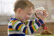 Caucasian boy pouring syrup on pancakes
