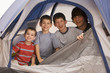 Smiling boys sitting in tent together