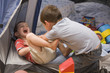 Caucasian boys playing in tent