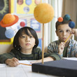 Boys studying the planet model in classroom