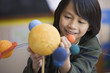 Pacific Islander boy making planet model in classroom