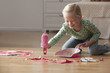 Caucasian girl cleaning up mess from floor