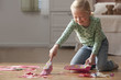 Caucasian girl cleaning up mess from floor