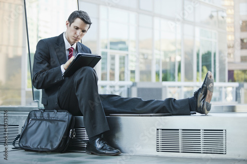 Photo: Caucasian businessman using digital tablet Caucasian businessman using digital tablet