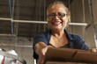 Hispanic woman packing boxes in factory