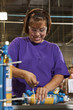 Hispanic worker assembling bottle in factory