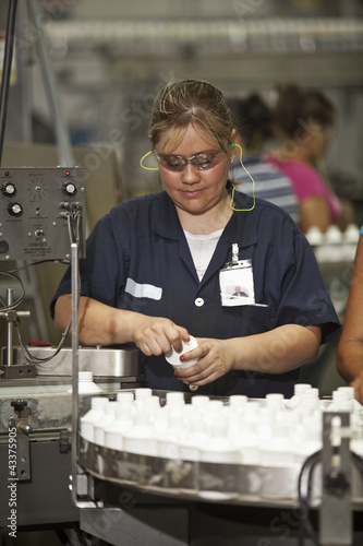 Photo: Hispanic woman working on assembly line Hispanic woman working on assembly line