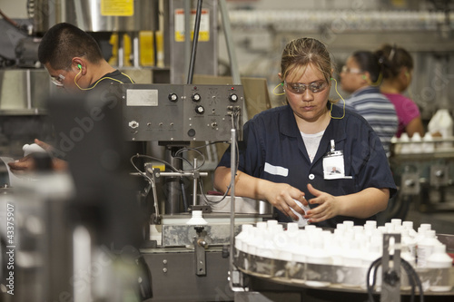 Photo: Hispanic woman working on assembly line Hispanic woman working on assembly line