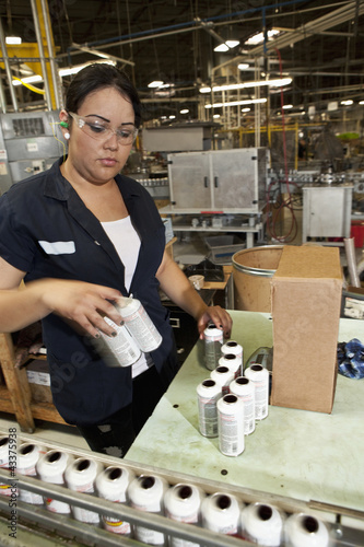Photo: Hispanic worker packing boxes in factory Hispanic worker packing boxes in factory