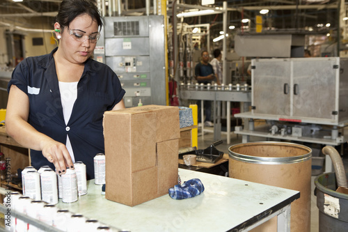 Photo: Hispanic worker packing boxes in factory Hispanic worker packing boxes in factory