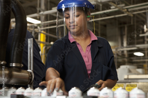 Photo: Hispanic woman working on assembly line Hispanic woman working on assembly line