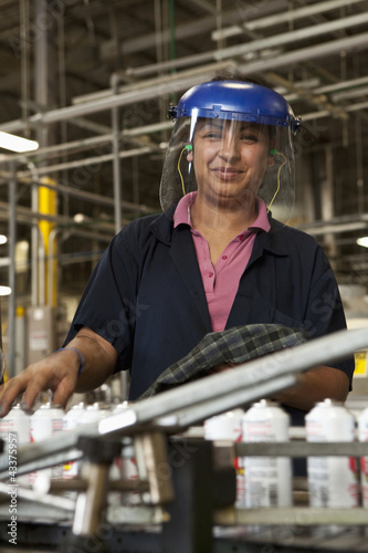 Photo: Hispanic woman working on assembly line Hispanic woman working on assembly line