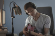 Mixed race boy strumming guitar and recording it on computer
