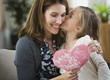 Caucasian girl giving Valentine to mother