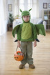 Mixed race boy in Halloween dragon costume
