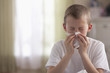 Caucasian boy blowing nose