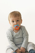 Mixed race baby boy sucking pacifier