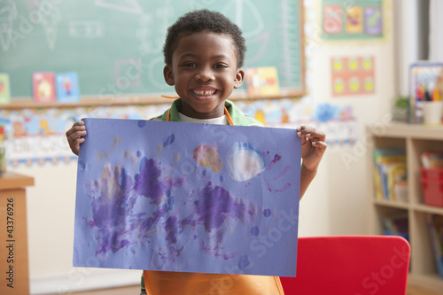 Photo: Black boy holding painting in art class Black boy holding painting in art class