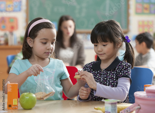 Photo: Girls eating lunch together in classroom Girls eating lunch together in classroom