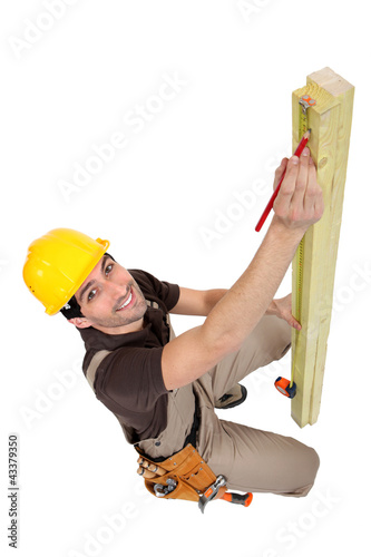 Foto: craftsman measuring a wooden board craftsman measuring a wooden board