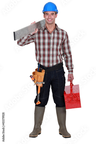 Photo: Worker carrying an aluminium plank and a toolbox Worker carrying an aluminium plank and a toolbox