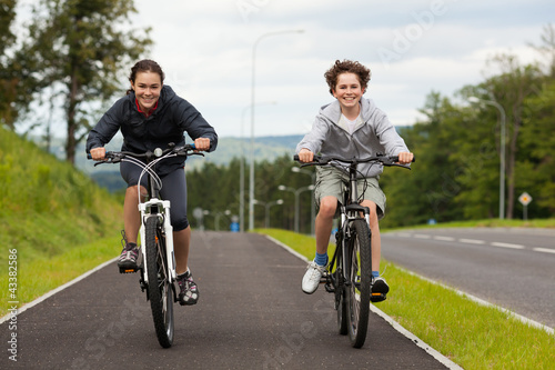 Photo: Girl and boy biking Girl and boy biking
