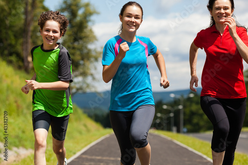 Photo: Active family - mother and kids running outdoor Active family - mother and kids running outdoor