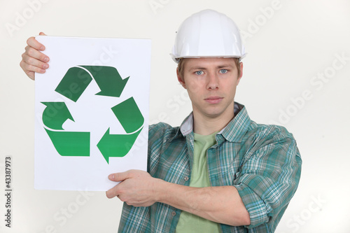 Photo: Builder holding the universal recycling symbol Builder holding the universal recycling symbol