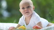Baby boy lying on grass with vegetables