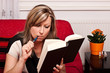 Blonde Frau mit Buch dampft elektrische Zigarette