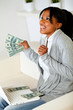Photo: Afro-american woman looking up with dollars Afro-american woman looking up with dollars