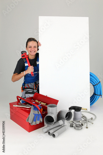 Foto: Woman with blank board and toolbox Woman with blank board and toolbox