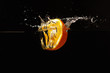 Halved fresh orange falling into the water with a splash