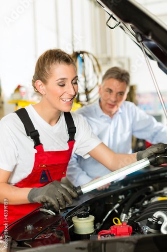 Photo: Älterer Mann und junge Mechanikerin am Auto Älterer Mann und junge Mechanikerin am Auto