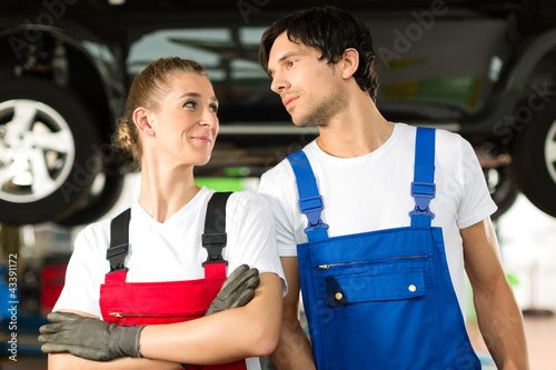 Photo: Auto Mechaniker Paar steht in Autowerkstatt Auto Mechaniker Paar steht in Autowerkstatt