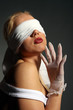 young girl blindfolded and wearing white gloves
