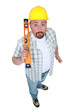 Surprised builder holding spirit-level