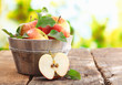 Wooden tub full and a halved fresh apple