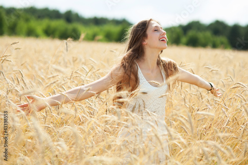 Foto: Woman in the wheat field with arms outstretched Woman in the wheat field with arms outstretched