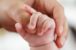 Baby greift nach Mutterhand