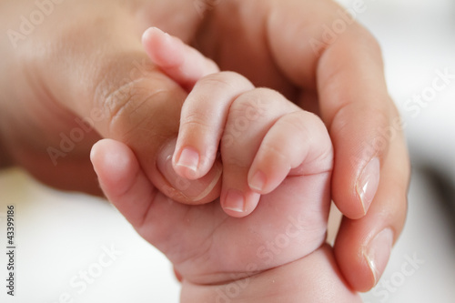 Photo: Baby greift nach Mutterhand Baby greift nach Mutterhand