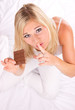 Photo: Beautiful blond girl with chocolate bar eating it in secret Beautiful blond girl with chocolate bar eating it in secret