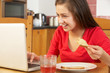 Foto: Teenage Girl Using Laptop Whilst Eating Breakfast Teenage Girl Using Laptop Whilst Eating Breakfast