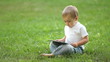 Video: Child working with the Tablet PC sitting on grass Child working with the Tablet PC sitting on grass