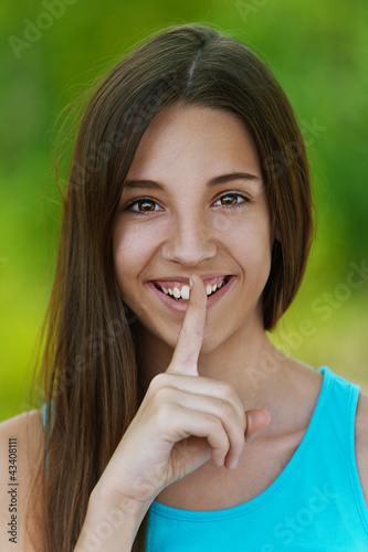 Foto: beautiful teenage girl puts finger to his lips beautiful teenage girl puts finger to his lips