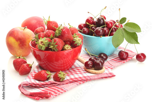 Photo: Ripe strawberries and cherry berries in bowls isolated on white Ripe strawberries and cherry berries in bowls isolated on white