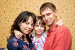 Father, mother and daughter hugging and smiling