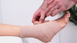 Physiotherapist strapping the ankle of his patient