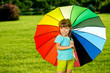 Photo: Smiling Little girl Kid in park with colorfull umbrella Smiling Little girl Kid in park with colorfull umbrella